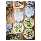 IKEA 365+ blauwe bakjes met deksel en soep en brood. Ronde, doorzichtige plastic voedselcontainers met blauwe klikdeksels gevuld met broccolisoep.