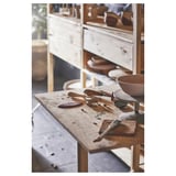 Houten ambachtelijke tafel met gereedschappen. Kommen, messen en klei. Planken met houten voorwerpen. Rustieke, natuurlijke omgeving.