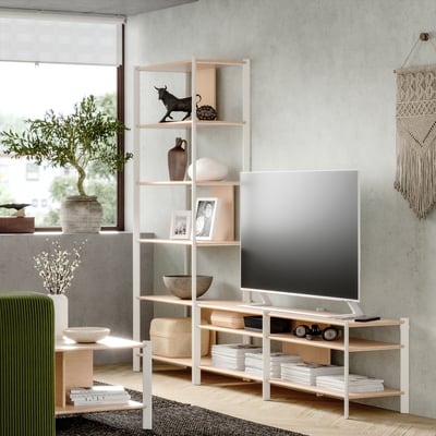 Moderne woonkamer met houten planken, tv, groene stoel en planten.