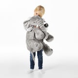 Kind dat groot grijs olifant pluche speeltje koestert, met slappe oren en witte slagtanden, die zijn rol als troostende en knuffelige metgezel demonstreren.