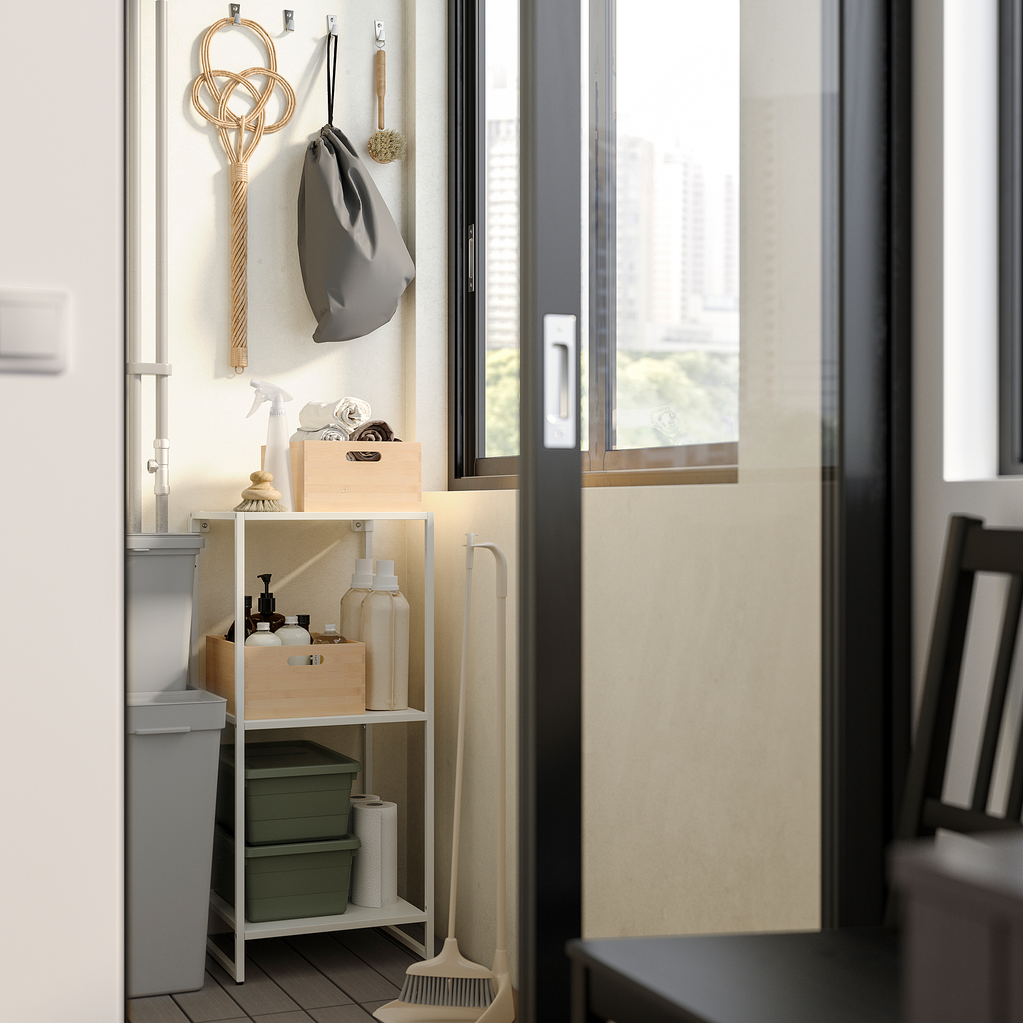 Klein opbergrek in de badkamer met planken met schoonmaakspullen, naast een raam met een dweil en haken voor accessoires, alles netjes georganiseerd.
