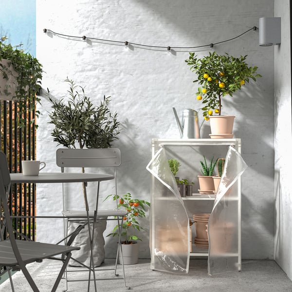 Balkon met JOSTEIN berging, planten en lichtslingers.