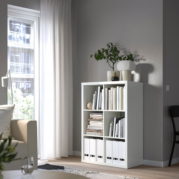 KALLAX boekenkast met decor door raam, stoelen, modern.
