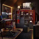 Modern thuiskantoor met KALLAX zwarte rekken, rode lichten, computerbureau, stoel, gitaar en decor.