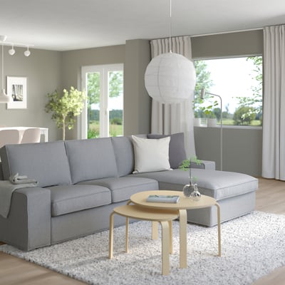 Moderne woonkamer met KIVIK bank, salontafel, hanglamp, raam met gordijnen.