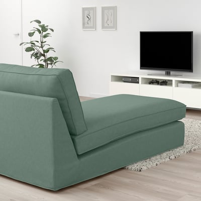 Moderne groene KIVIK chaise longue onder tv, zacht en duurzaam, past in een gezellige woonkamer.