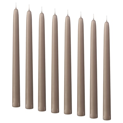 Negen beige kaarsen staan gelijkmatig op een rij, cilindrische vorm, rechtop.