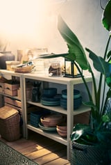 Witte KOLBJÖRN plank met decor, borden, schalen en plant.