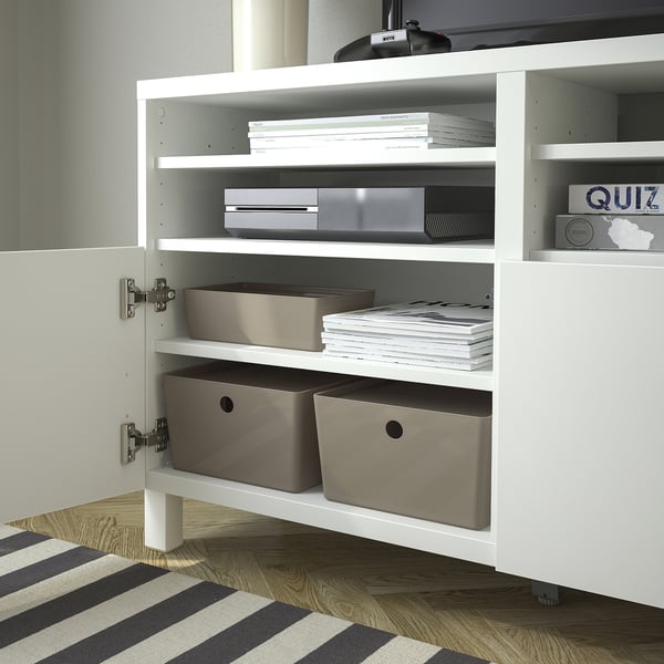 Wit kabinet met open deur, met georganiseerde planken. Inclusief grijze dozen, stapels papieren en elektronische items.