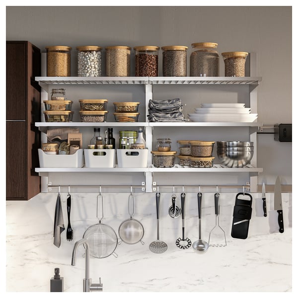 Moderne keuken met KUNGSFORS RVS opbergkast. Planken bevatten potten en containers, terwijl haken eronder keukengerei ophangen.