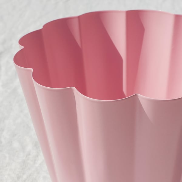 Een close-up van een roze, golvende plantenpot, die zijn gladde, hoogwaardige afwerking laat zien.