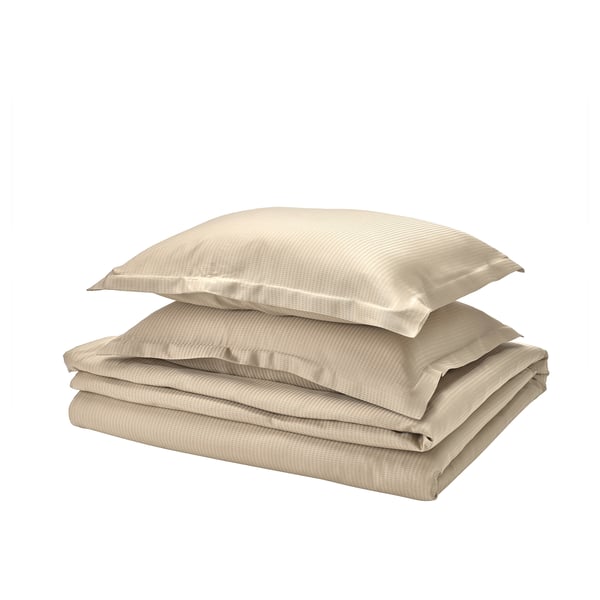 Gevouwen beige beddengoed. Inclusief dekbedovertrek en kussens met flensafwerking. Zachte, zijdeachtige lyocell-stof.