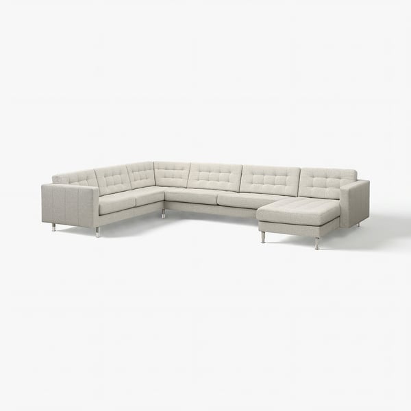 Moderne grijze L-vormige hoekbank met chromen poten en een getufted rugleuning en zitplaatsen.