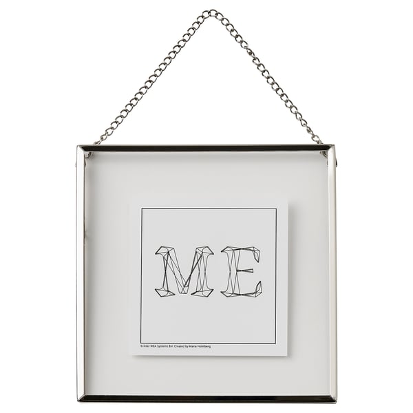 Zilveren, vierkante fotolijst met ketting, met zwarte lijnkunst letters me door Maria Holmberg.