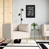 Moderne woonkamer met LILLEHEM-bank, geometrisch tapijt en camerakunst.