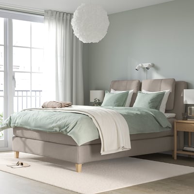 LILLFJÄLLET bed: grijs, gestoffeerd, hoofdeinde met kussens, grote, houten poten, neutrale inrichting.