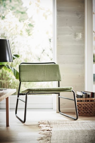 Moderne groene LINNEBÄCK stoel met zwart metalen frame, minimalistisch design.