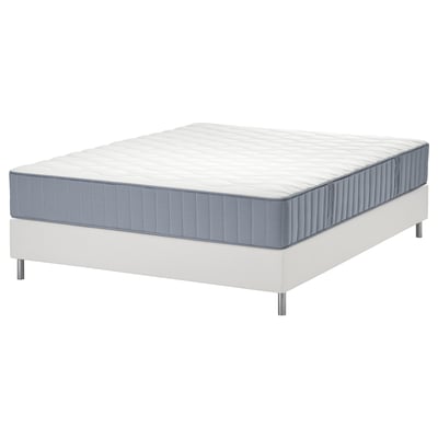 Wit LYNGÖR bed met grijze matras. Het heeft zeven comfortzones en een dubbellaags veersysteem voor ondersteuning en luchtstroom.