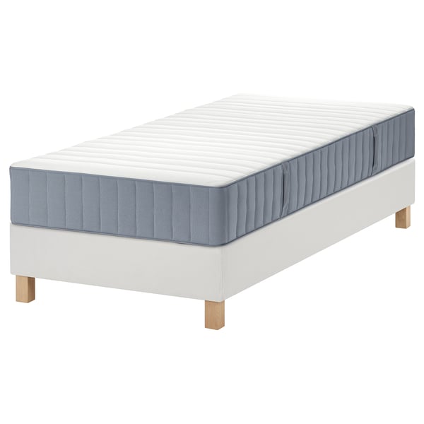Een wit houten bedframe met een blauw-witte matras; Modern minimalistisch design.