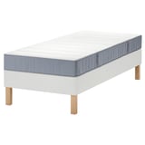 De LYNGÖR bedset, bestaande uit een witte bedbodem en een grijze vesteröy matras met pocketveren. De bedbodem heeft stevige houten poten.
