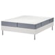 De witte LYNGÖR bedbodem met een blauwgrijze vesteröy matras. Vier metalen poten ondersteunen de basis en de matraszak veren voor comfort.