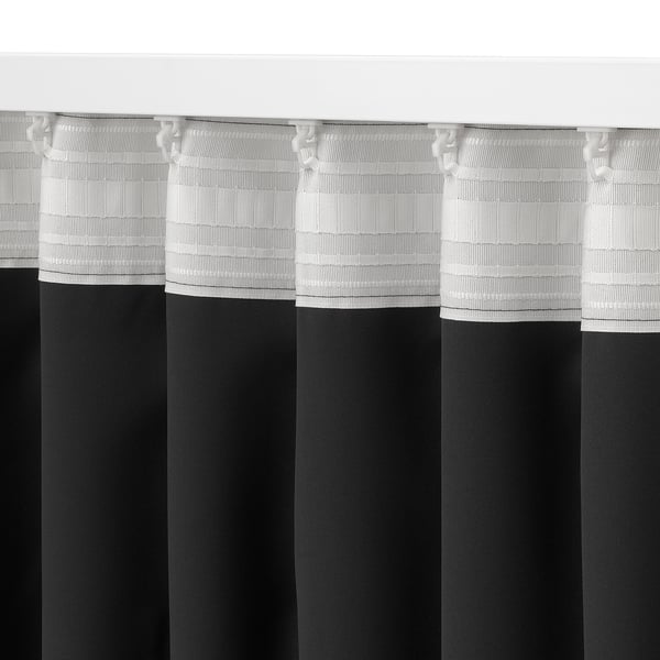 Verduisterende gordijnen hingen hoog, met plooien en haken, die het licht blokkeerden en privacy boden.