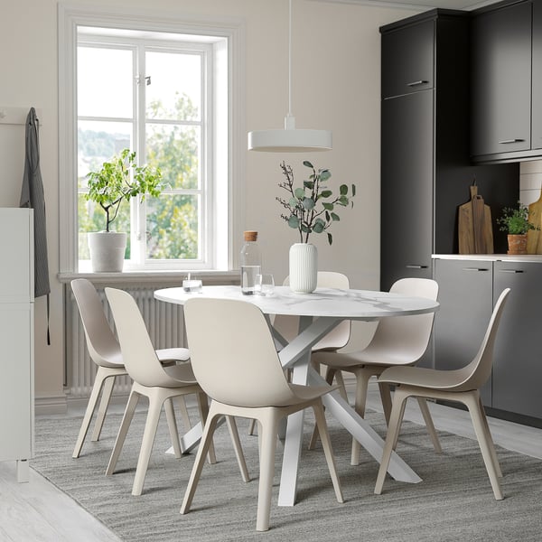Moderne eetopstelling met tafel, 4 stoelen en planten.