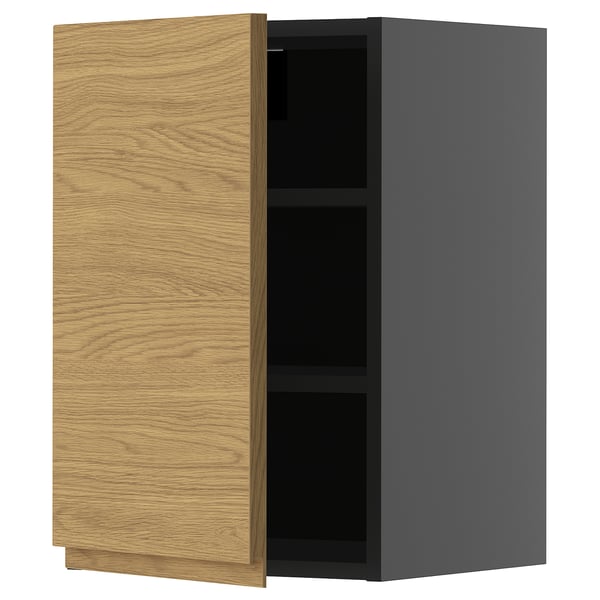 Een moderne keukenkast genaamd METOD. Het is een lichte houten deur met een minimalistisch design aan één kant en een strakke grijze buitenkant.