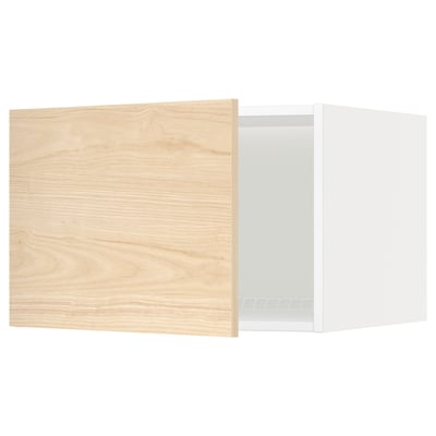 Een METOD keukenkast met een askersund deur met licht essenhoutpatroon. Het heeft een wit frame en een houten deur die op een kier staat.