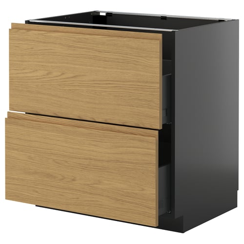 Een moderne keukenkast genaamd METOD met twee houten lades in een natuurlijke eiken afwerking en een strak zwart onderstel.