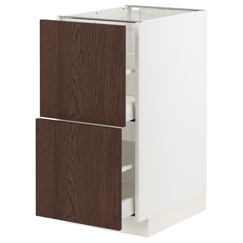 Donkerbruine houten lade in witte kast.