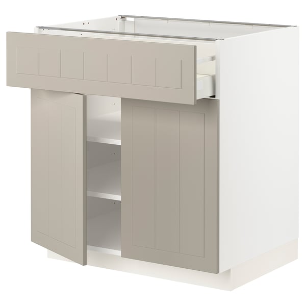 Een witte METOD keukenkast met beige stensund deuren, voorzien van een lade en verstelbare planken.