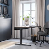 Modern kantoor aan huis met verstelbaar bureau, ergonomische stoel en opbergmeubel.