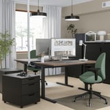Thuiskantoor met MITTZON bureau, groene stoel, dubbele monitoren, zwarte opbergers, kabelbeheer, minimalistisch design.