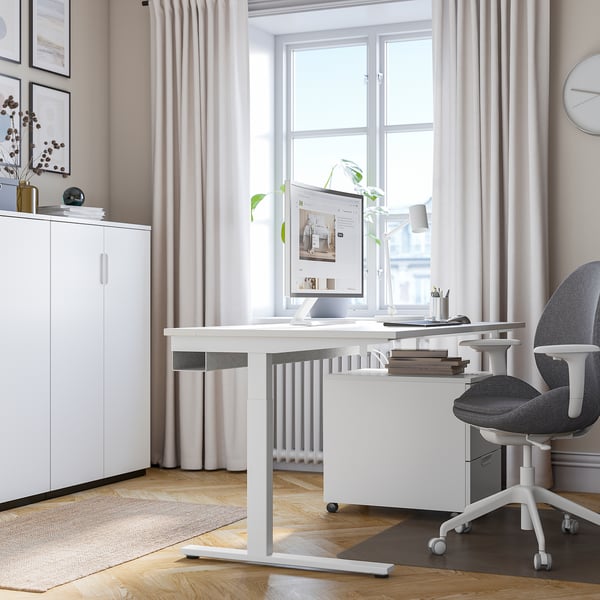 Modern thuiskantoor met MITTZON bureau, stoel en inrichting; witte kast, kunst en gordijnen.