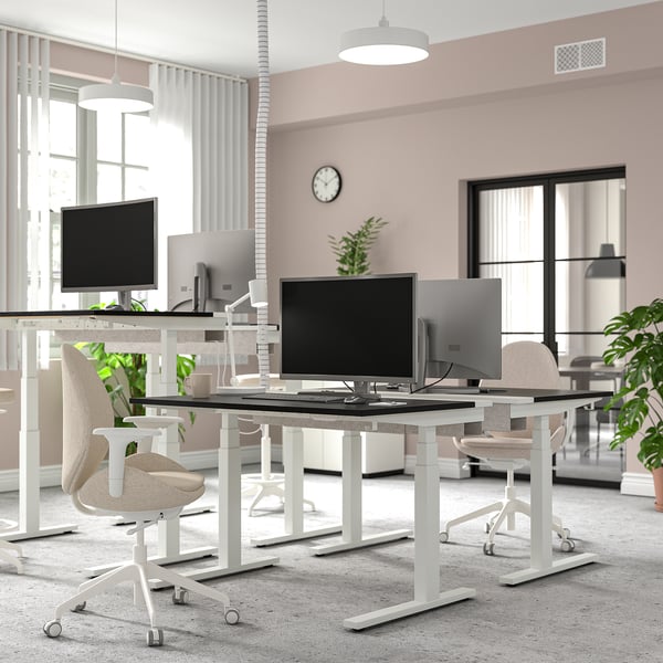 Modern kantoor met MITTZON zit-sta bureaus, strak design, stoelen en planten.