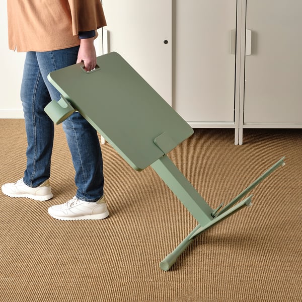 Persoon die de hoogte van de groene MITTZON laptoptafel met een gasveermechanisme aanpast.