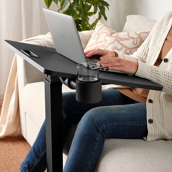 Persoon die MITTZON laptoptafel gebruikt, hoogte aanpast, typt op laptop.