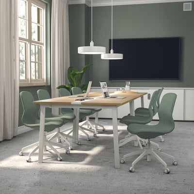 Vergaderruimte met MITTZON-tafels en långfjäll-stoelen, groene muren, tv en grote ramen.