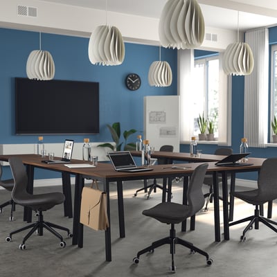 Moderne vergaderruimte met blauwe muren, houten tafels, zwarte stoelen, hanglampen, tv. MITTZON tafels in u-vorm, ruim.