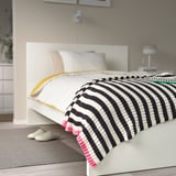 Gezellige zwart-wit gestreepte MOSSMOTT gooi op bed, groter dan pantoffels, zacht gerecycled polyester.