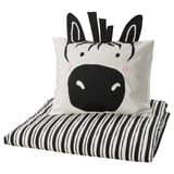 Zebra-thema zwart-wit kussen op gestreepte deken.