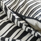 Close-up van zwart-wit gestreept dekbed; Rits detail.