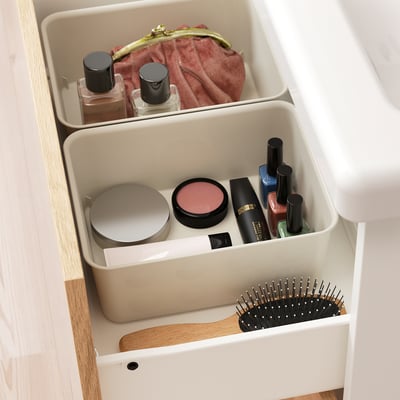 Lange plastic organizerlade met make-up artikelen en borstel. Maximaliseert de ruimte en houdt alles netjes.