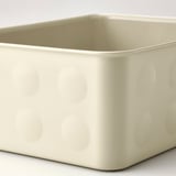 Gebroken witte plastic opbergdoos met getextureerde cirkels in reliëf. Stevig voor het organiseren van items.
