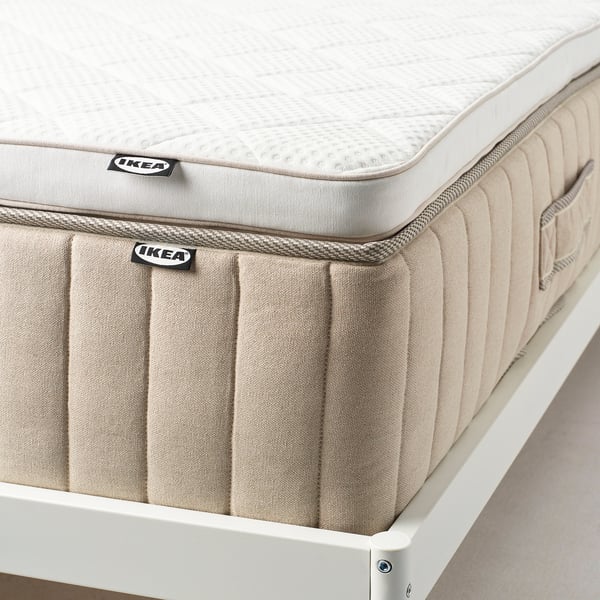 Ikeas nylåget matrasbeschermer op standaard. Toont latex- en stofontwerp, regelt de temperatuur en ondersteunt comfort.
