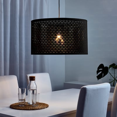 Modern dineren met NYMÖ zwarte hanglamp, blauwe stoelen, witte tafel, gordijnen.