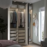 Moderne slaapkamer met open PAX-kast, met kleding, manden en accessoires in lichte kleuren.