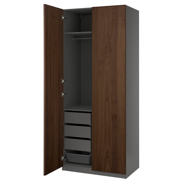 PAX kledingkast: hoge, donkerbruine houten deuren, grijs interieur met planken en lades, modern design.
