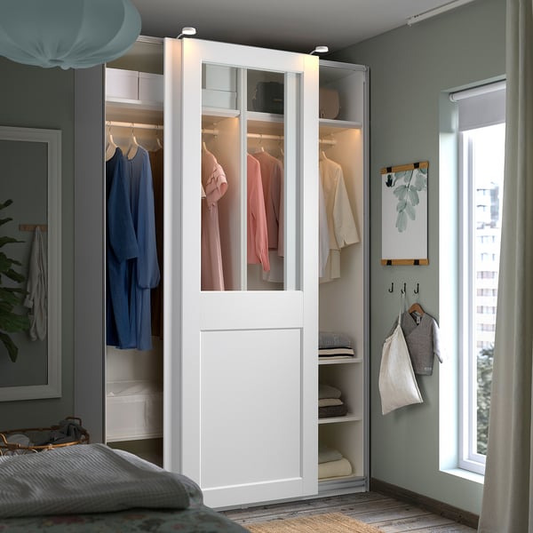 Georganiseerde slaapkamer met witte PAX kledingkast, groene muren en gezellig bed.